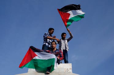 Palestinians hold national flags as they celebrate after an announcement of a reconciliation agreement in Gaza City April 23, 2014. (Reuters)