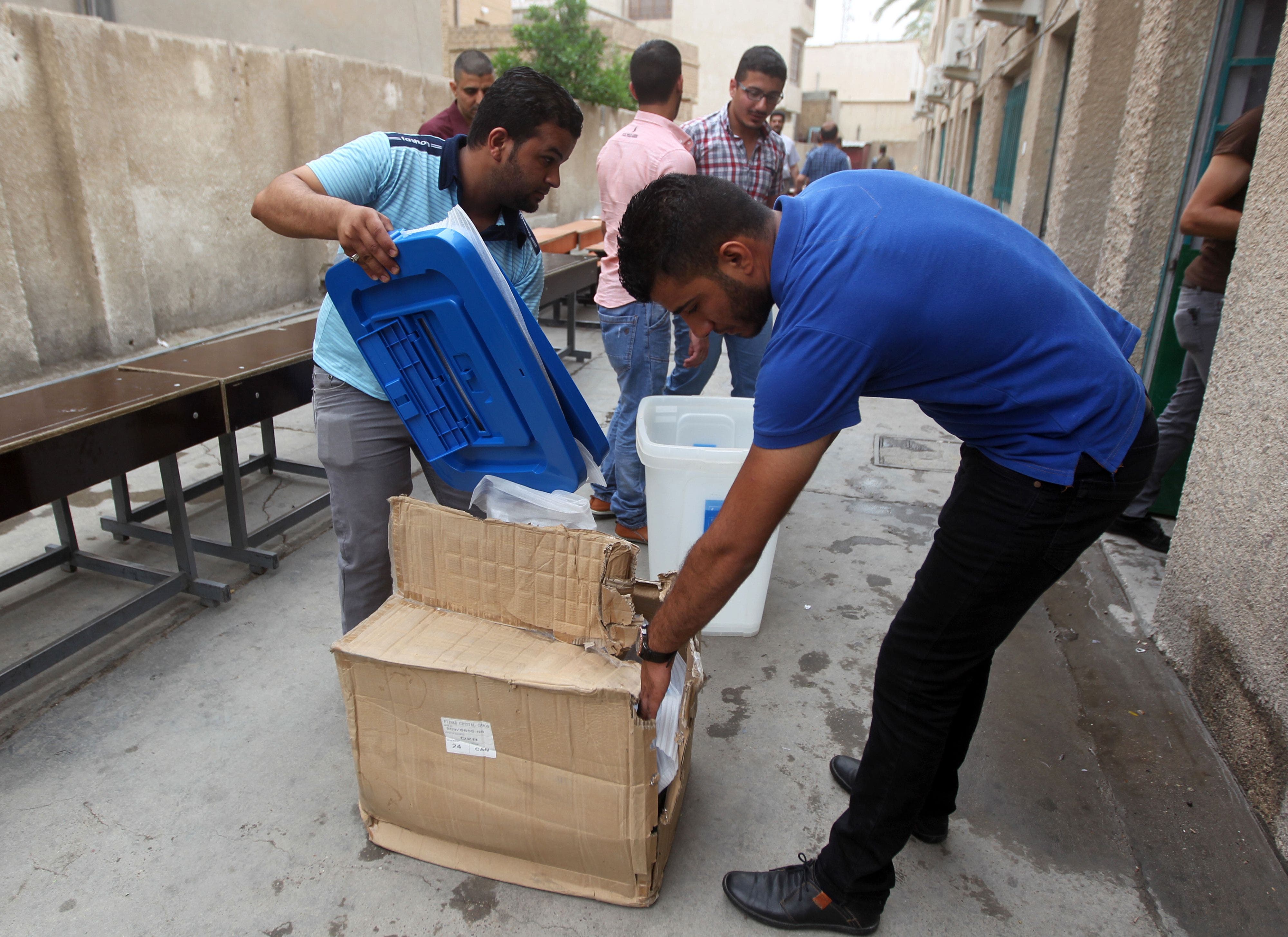 Employees distribute election material during vote preparations at a polling station on April 27, 2014 in the capital Baghdad ahead of the upcoming parliamentary elections in Iraq. (AFP)