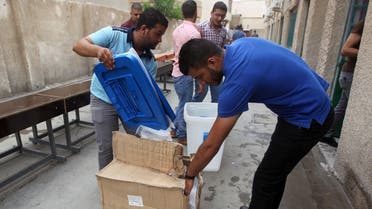 Employees distribute election material during vote preparations at a polling station on April 27, 2014 in the capital Baghdad ahead of the upcoming parliamentary elections in Iraq. (AFP)