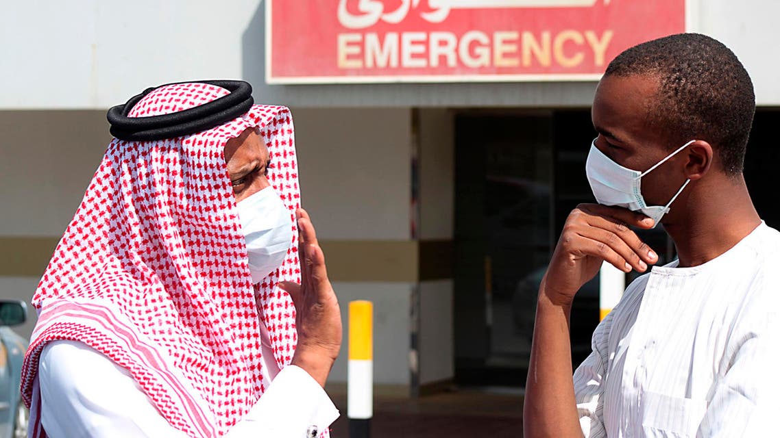 Men wearing surgical masks as a precautionary measure against the novel coronavirus, speak at a hospital in Khobar city in Dammam May 23, 2013. (Reuters)