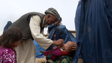 A landslide-affected child receives polio vaccination drops during aid distribution at the scene of the disaster in Argo district of Badakhshan on May 4, 2014. (AFP)