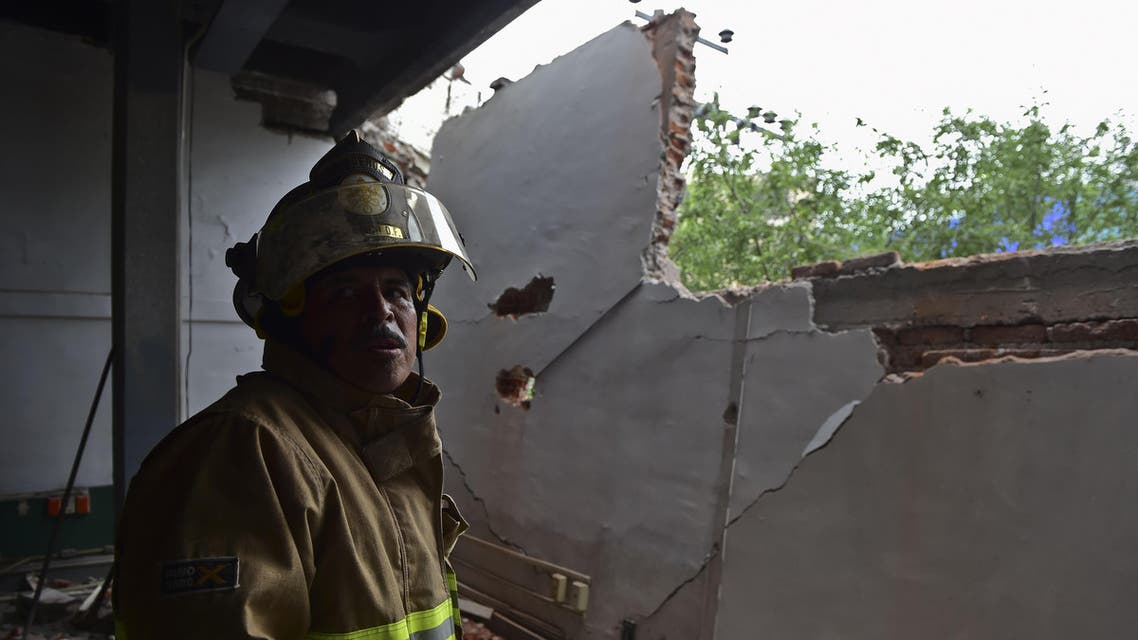 A firefighter works to demolish a damaged wall after a strong earthquake in Mexico City on May 8, 2014. (AFP)
