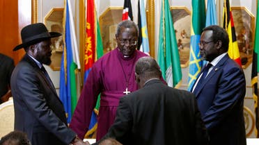 South Sudan's rebel leader Riek Machar (R) and South Sudan's President Salva Kiir (L) hold a priest's hands as they pray before signing a peace agreement in Addis Ababa May 9, 2014.  reuters