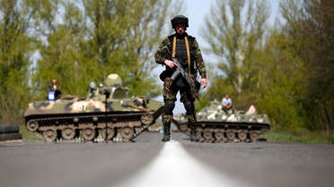 A Ukrainian soldier stands guard in front of armoured personnel carriers at a check point near the village of Malinivka, south-east of Slaviansk, in eastern Ukraine April 27, 2014. reuters