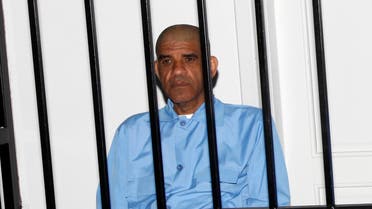 Abdullah al-Senussi, former spy chief under the government of late Libyan leader Muammar Gaddafi, sit behind bars during a hearing at a courtroom in Tripoli May 11, 2014. (Reuters)