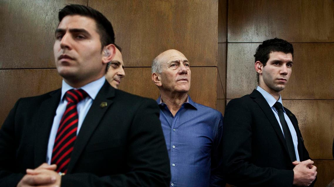 Former Israeli Prime Minister Ehud Olmert (2nd R) waits to hear his verdict at the Tel Aviv District Court March 31, 2014. 