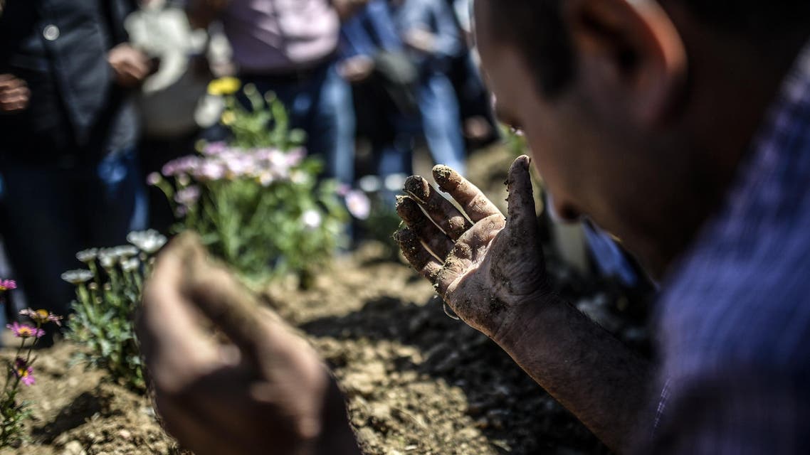 People mourn their relatives at the cemetery where some of the 301 people killed after an explosion and fire in a coal mine were buried, on May 18, 2014, at Soma in Manisa.