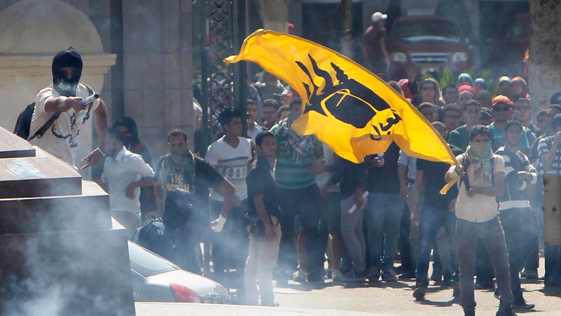A student supporter of the Muslim Brotherhood and ousted President Mohamma Mursi stands with others amidst tear gas fired by riot police after clashes broke out during a demonstration outside Cairo, May 14, 2014. (Reuters)
