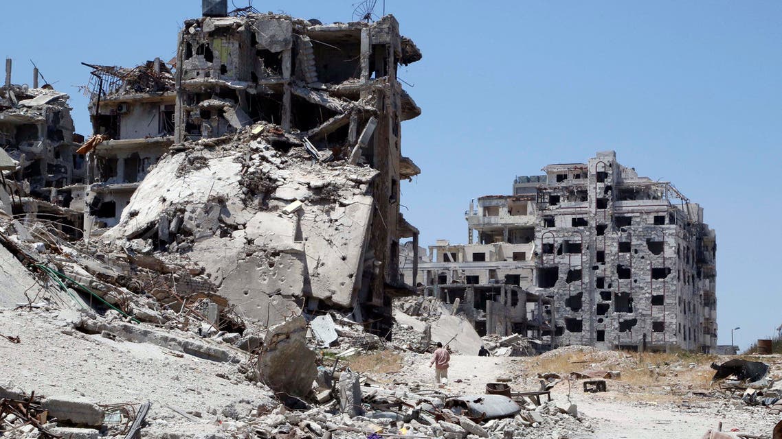 Men walk past damaged buildings as they head to inspect their homes in the Wadi Al-Sayeh district at the al-Khalidiyeh area in Homs May 14, 2014. (Reuters)