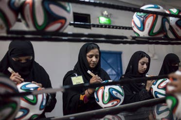Employees conduct a final check to fix any cavities in the seams of balls inside the soccer ball factory that produces official match balls for the 2014 World Cup in Brazil, in Sialkot, Punjab province May 16, 2014. (Reuters)