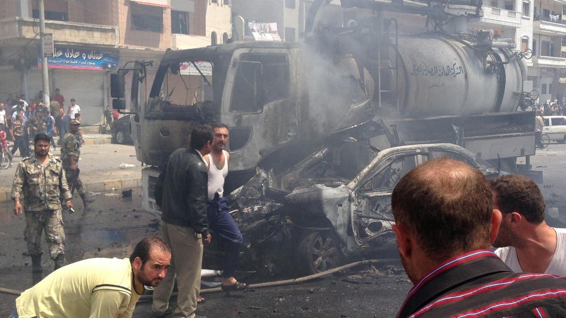 A picture taken with a smartphone on May 25, 2014, shows emergency teams gathering at the site of a car bomb attack in a regime-held area in Syria's central city of Homs, that left at least eight people dead and tens injured, according to the governor of Homs. afp