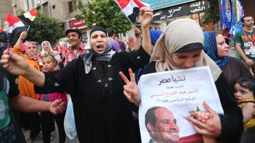 Egyptian supporters of former army chief and presidential candidate Abdel Fatah al-Sisi (portrait) wave their national flag and chant slogans in a street in Cairo on the second day of Egypt's presidential election May 27, 2014. (AFP)