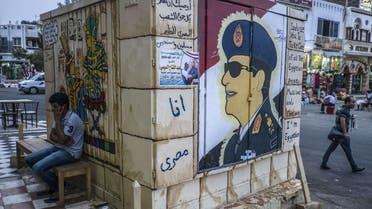 Egyptian man sitting next to graffiti of Egypt's ex-army chief and leading presidential candidate Abdel Fattah al-Sisi. (AFP)