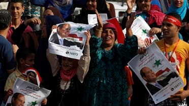 People hold up Sisi posters as they celebrate outside a polling station during the presidential elections in Cairo May 26, 2014. reuters