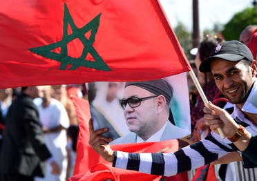Moroccans living in Tunisia welcome King Mohamed VI (portrait) in Tunis.  (AFP)