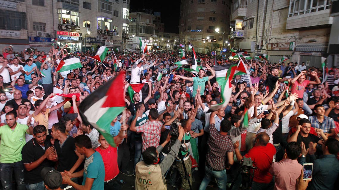 Palestinians celebrate in Ramallah after their national team qualified for the Asian Cup for the first time. (Reuters)