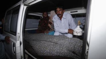 Mohammad Iqbal sits next to his wife Farzana's body, who was killed by family members, in an ambulance outside of a morgue in Lahore May 27, 2014. (Reuters)