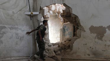 A Free Syrian Army fighter goes through a hole in the wall heading towards the frontline in Old Aleppo May 31, 2014. 