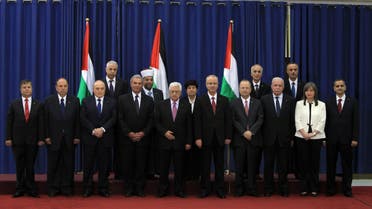  Palestinian president Mahmud Abbas (C) poses for a picture with the members of the new Palestinian unity government in the West Bank city of Ramallah June 2, 2014. 