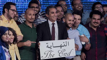 Egyptian satirist and television host Bassem Youssef (C) and his team hold a placard reading in Arabic “the end” during a press conference to announce the end of his TV show on June 2, 2014 in the capital Cairo. (AFP)