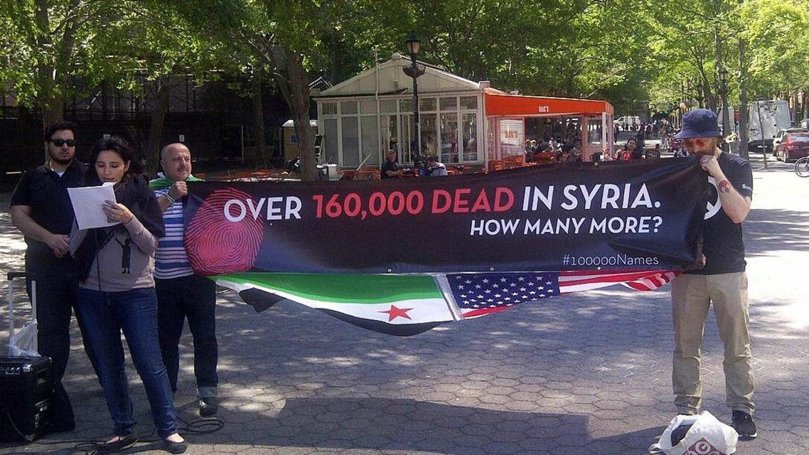 Protesters stand in front of the United Nations, to read the names of the over 100,000 people killed in Syria, on June 2, 2014. (AFP)