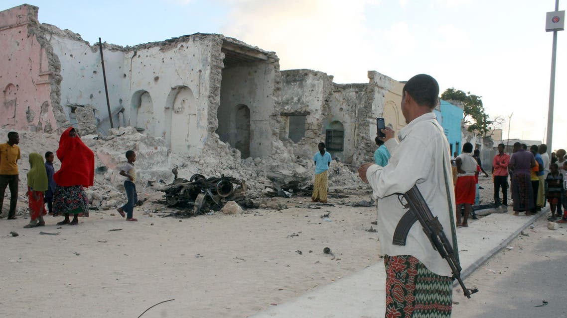 A Somali soldier takes a picture with his mobile phone of an explosion site on May 31, 2014. (AFP)