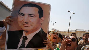 Supporters of former president Hosni Mubarak hold his poster to celebrate his release in front of the main gate of Tora prison on the outskirts of Cairo August 22, 2013.  (Reuters)