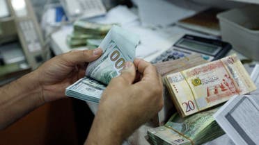 A man counts U.S. dollars at a currency exchange office in central Tripoli, June 3, 2014. (Reuters) 