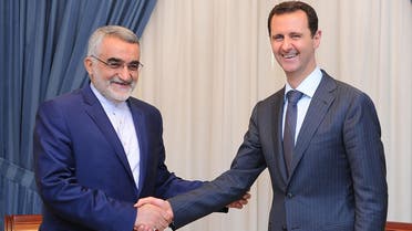 Syrian President Bashar al-Assad (R) shaking hands with The Chairman of the Foreign Policy and National Security Committee at the Iranian Shura Council, Alaeddin Boroujerdi in Damascus on June 5, 2014. (AFP)