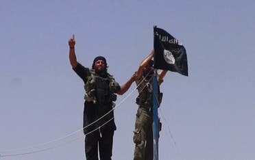 ISIS Militants hanging the Islamic Jihad flag on a pole at the top of an ancient military fort after they cut a road through the Syrian-Iraqi border. (AFP)