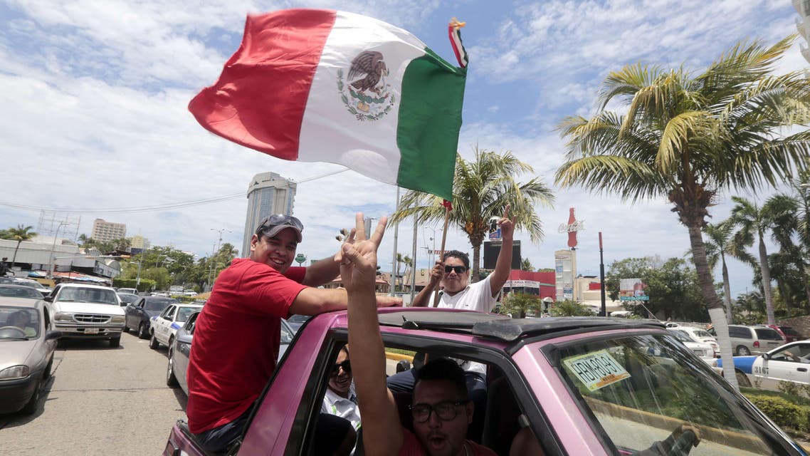 Mexican fans celebrate their win at the end of the Mexico vs Cameroon World Cup football match, at Zocalo Square in Mexico City on June 13, 2014. (AFP)