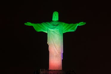 The statue of the Christ the Redeemer is seen lit with the colours of Iran's flag during the changing of all 32 nations' colors participating in the FIFA World Cup Brazil 2014 atop Corcovado hill in Rio de Janeiro, Brazil, on June 11, 2014. (AFP)