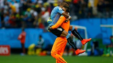 Uruguay's Jose Maria Gimenez (top) hugs teammate Fernando Muslera after Luis Suarez (unseen) scored against England during their 2014 World Cup Group D soccer match at the Corinthians arena in Sao Paulo June 19, 2014.