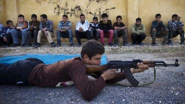 Syrian youth Sobhi, 15, holds an AK-47 assault rifles as he takes part in a military training on January 23, 21013 at a former school turned into a 'military academy' in Tlaleen in the northern Syria's Aleppo province. AFP