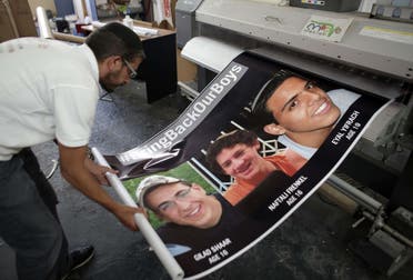  An Israeli printer finalizes posters in Jerusalem on June 23, 2014, of the three youth Israelis who disappeared from a hitchhiking stop in the southern West Bank on June 12. (AFp)