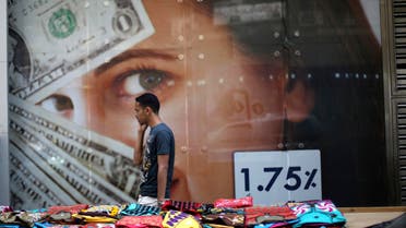 A pedestrian walks past a currency exchange shop and street stalls after Abdel Fattah al-Sisi took more than 90 percent of the vote in a presidential election, according to provisional results, in Cairo, May 29, 2014. (Reuters)