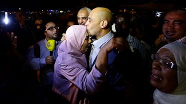Tunisian diplomat Al-Aroussi Kontassi (C) hugs a family member upon his arrival at a military airport at Aouina in Tunis early June 30, 2014. 