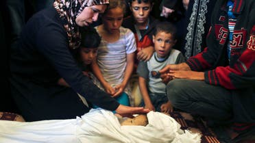 The mother of three-year-old Palestinian girl Jud al-Danaf touches her body during her funeral in Gaza City June 25, 2014. 