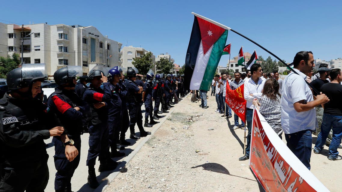 Police officers stand guard during a protest calling for an end to the Israeli air strikes in the Gaza Strip, near the Israeli embassy in Amman July 11, 2014.