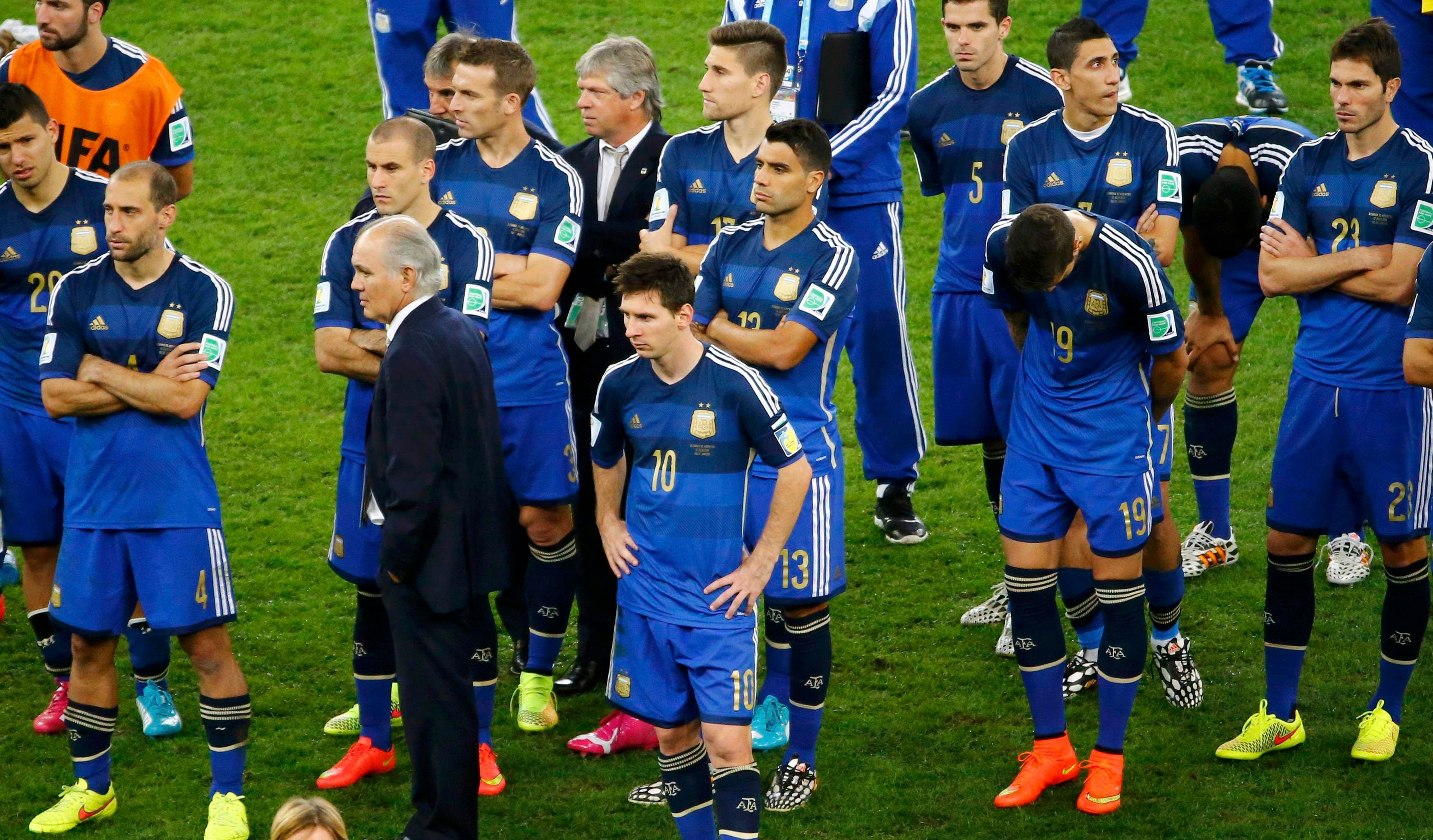 Argentina's coach Alejandro Sabella stands between his players after their loss to Germany in their 2014 World Cup final at the Maracana stadium in Rio de Janeiro July 13, 2014. 