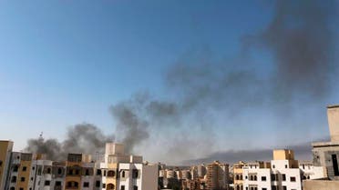 Smoke rises near buildings after heavy fighting between rival militias broke out near the airport in Tripoli July 13, 2014. 