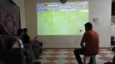  Palestinians watch a television projection of a live telecast displaying the the 2014 FIFA World Cup final between Argentina and Germany in Brazil, in the southern Gaza Strip town of Rafah on July 13, 2014. AFP 