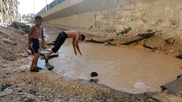 Syrian children play in a bomb crater flooded with water from a broken main in the northern city of Aleppo. (AFP)