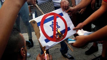 Demonstrators burn a placard with a picture of Israel's flag during a protest in Barcelona, against Israel's military action in Gaza, July 17, 2014. 