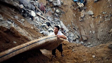 A Palestinian salvages a mattress from the remains of a house, which police said was destroyed in an Israeli air strike, in Khan Younis in the southern Gaza Strip July 21, 2014 reuters