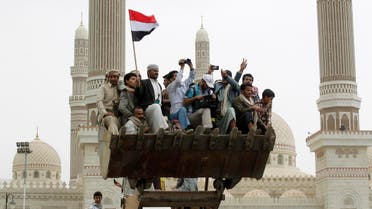 People ride on a bulldozer during the funeral of army commander Brigadier General Hameed al-Qushaibi in Sanaa July 23, 2014.  Reuters