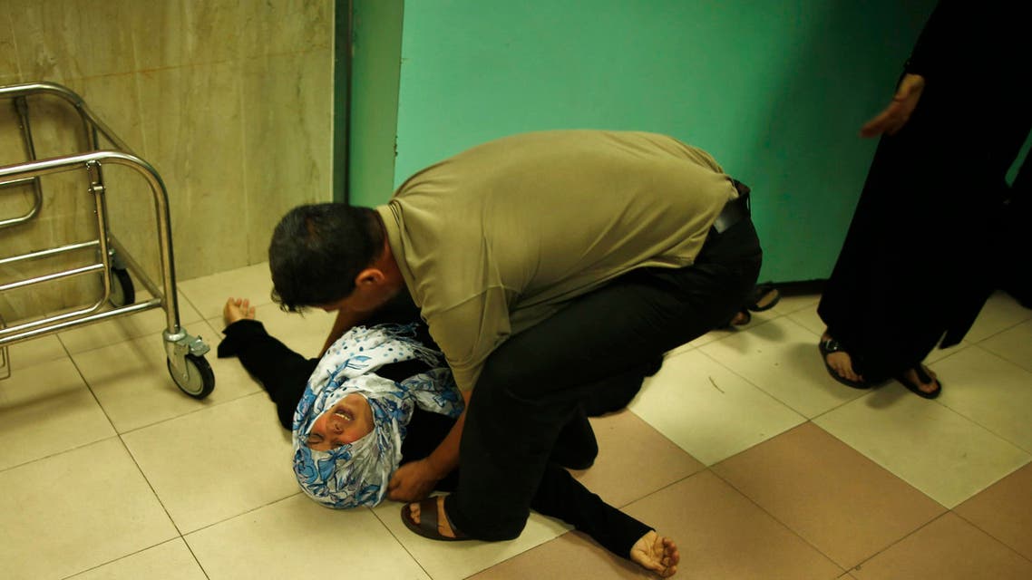 A Palestinian mother lies on the ground as she mourns the death of her son, who medics said was killed by Israeli shelling, at a hospital in Gaza City July 23, 2014. (Reuters)