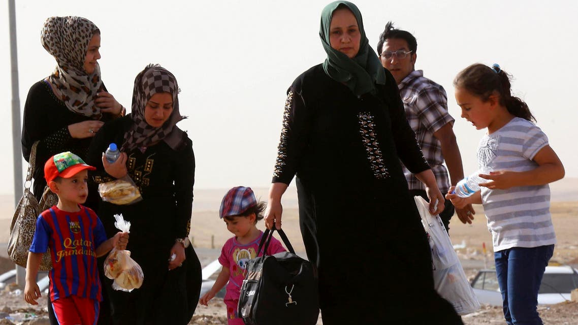 A family fleeing the violence in Mosul waits at a checkpoint on the outskirts of Arbil, in Iraq's Kurdistan region, June 11, 2014. (Reuters)