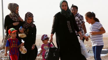 A family fleeing the violence in Mosul waits at a checkpoint on the outskirts of Arbil, in Iraq's Kurdistan region, June 11, 2014.  (Reuters)