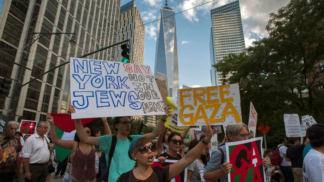 One World Trade Center is seen in the background as activists hold placards while shouting "Free, free Palestine" and "Not another nickel, not another dime, no more money for Israel's crimes," during a protest march through Lower Manhattan, New York July 24, 2014. Reuters